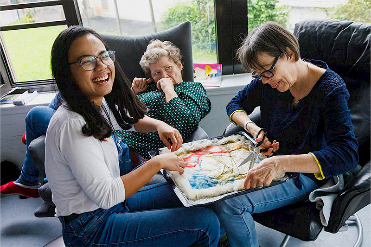 Bild zeigt mehrere Personen bei der Handarbeit.