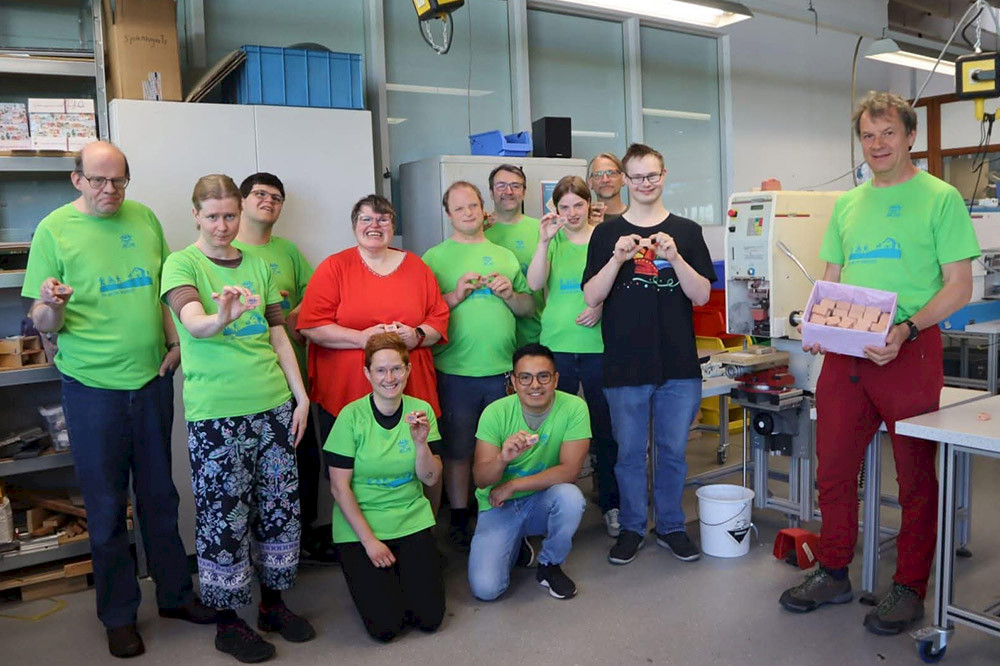 Bild zeigt eine Gruppe Personen in der Werkstatt.